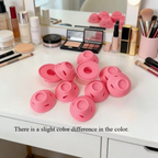 Elite Stationery House set of pink soft silicone no-heat hair curlers arranged on a white vanity table with makeup.