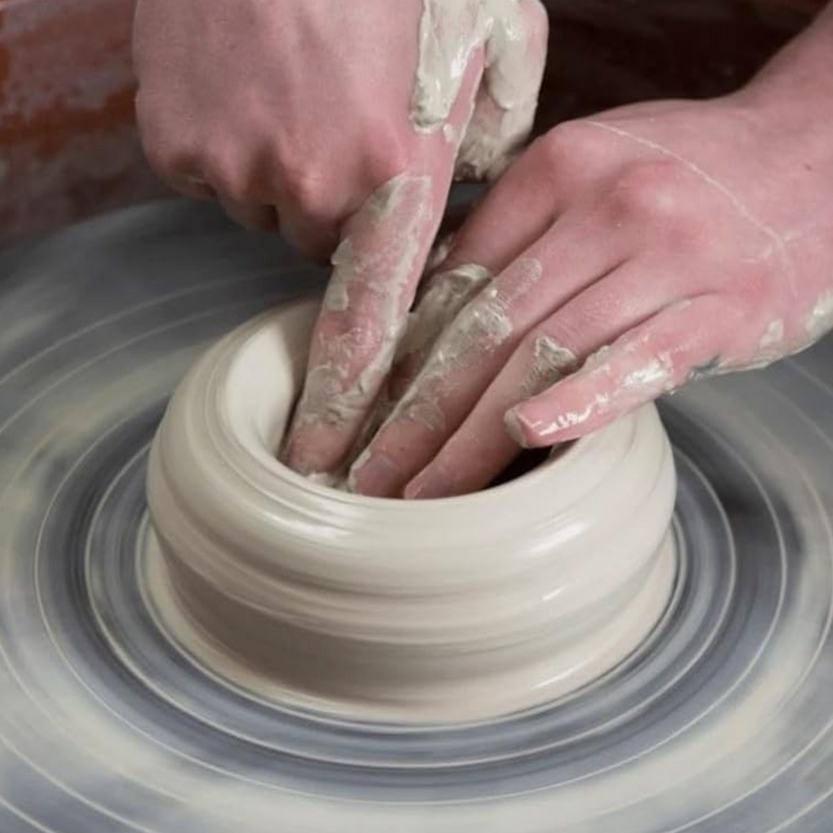 Elite Stationery House Aswan clay pottery dough being shaped by hands on a spinning potter's wheel