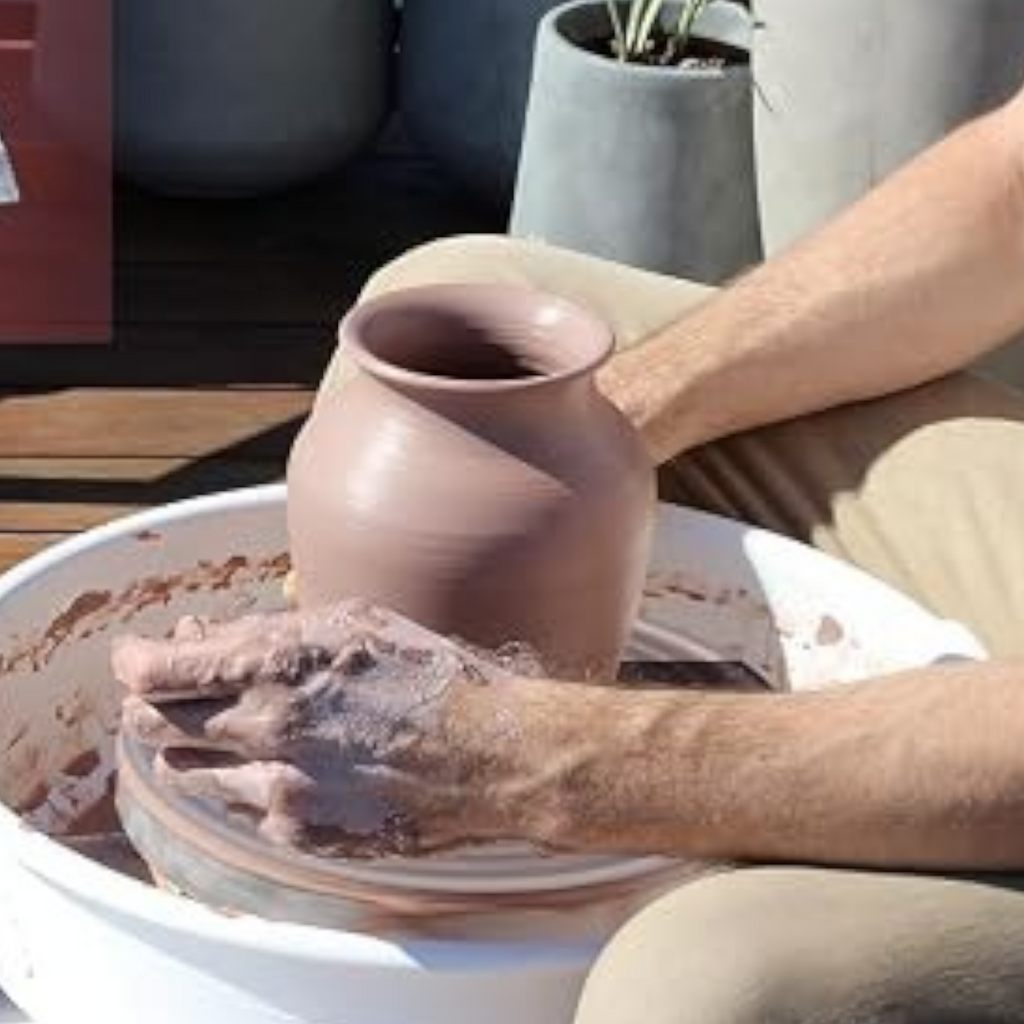 Elite Stationery House Aswan natural pottery clay being shaped into a vase on a spinning wheel with packaged clay inset