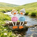 Elite Stationery House decorative duck figurines wearing knit sweaters and beanies sitting on a rock by a stream