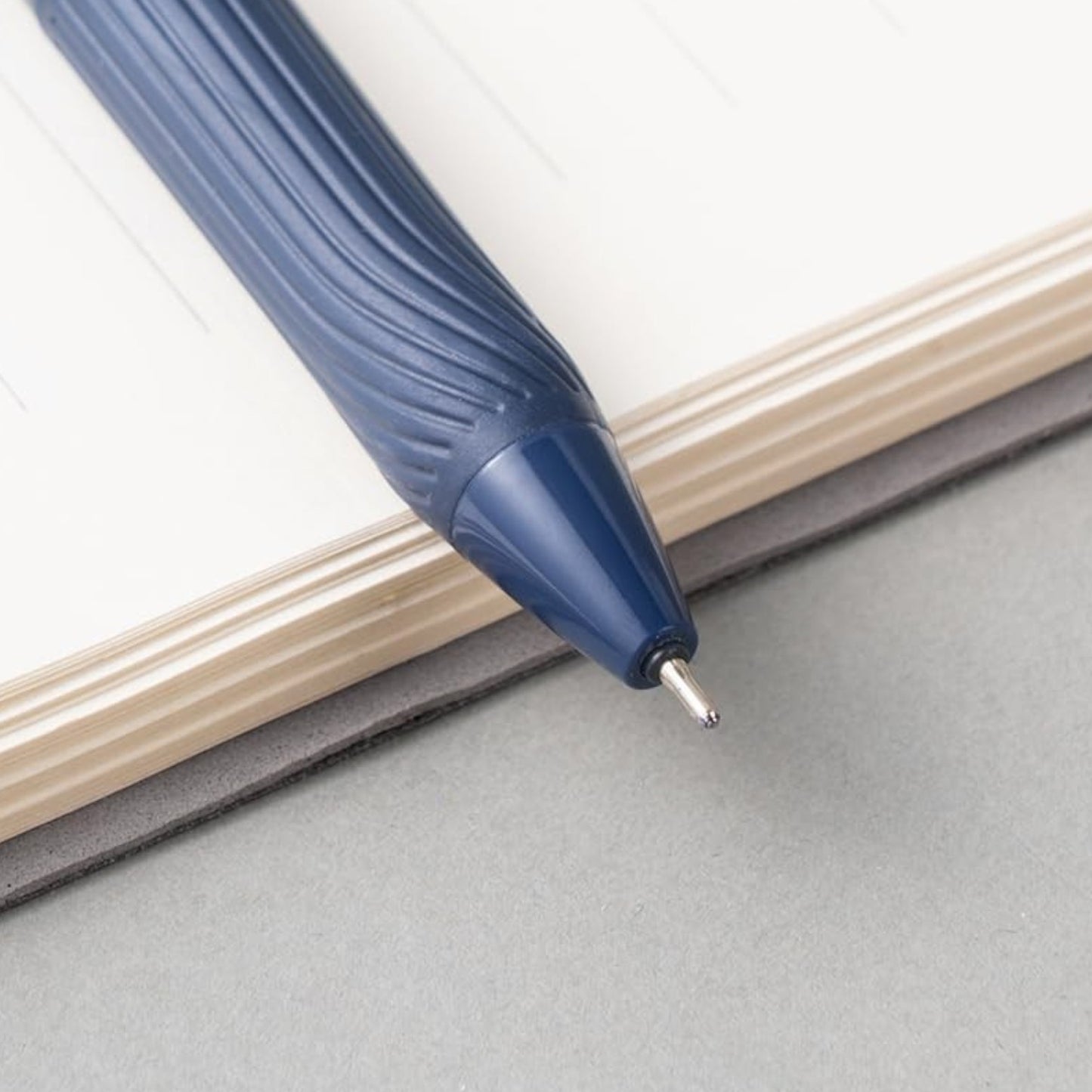 Elite Stationery House Deli Xtream blue ball point pen with a 0.7mm tip and textured soft grip on a notebook