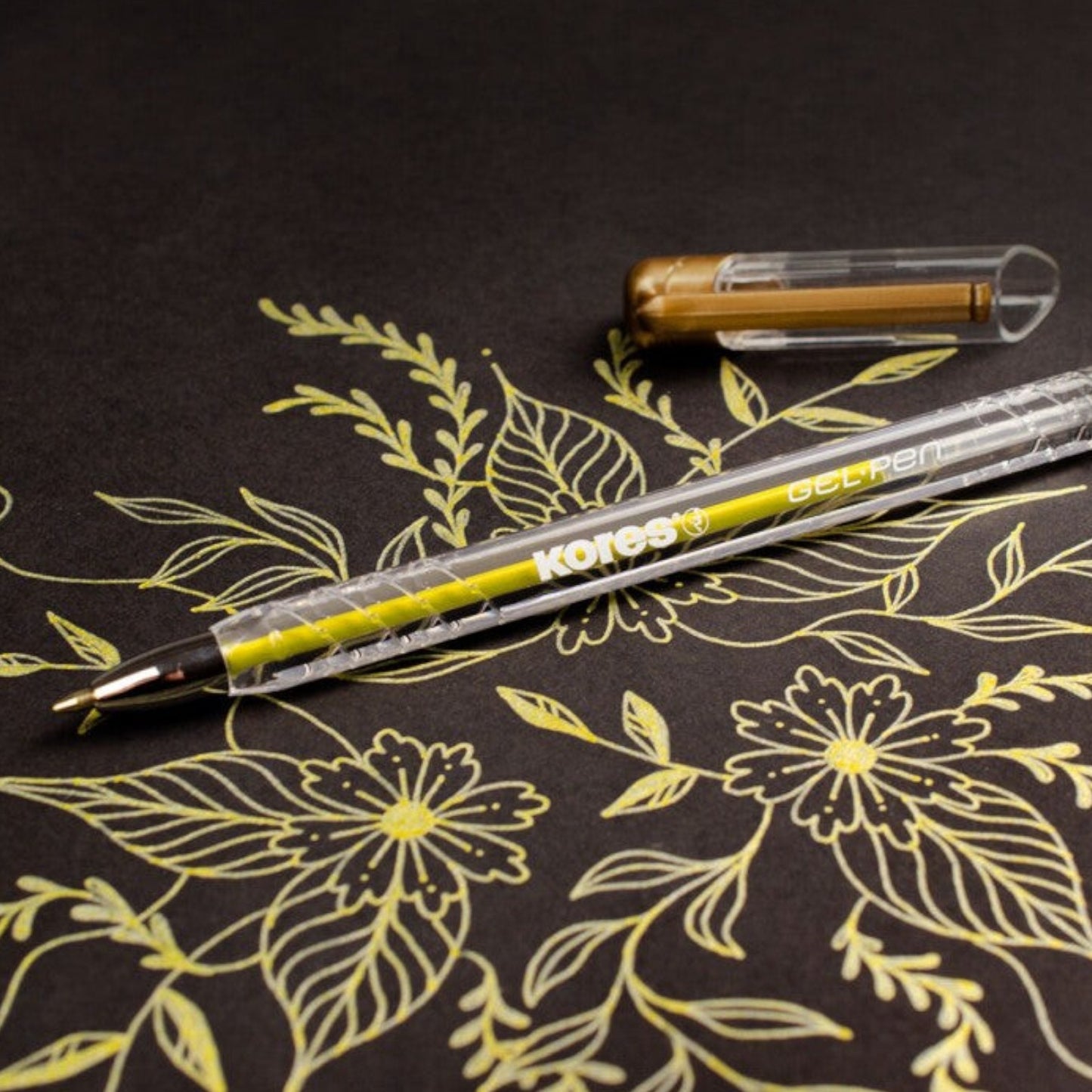 Elite Stationery House Kores metallic gold gel pen with 1mm tip drawing floral patterns on black paper