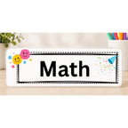 Elite Stationery House laminated Math subject label with smiley face icons and colorful confetti on a wooden desk